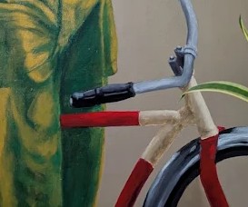 Detail of the red frame and wheel of the bicycle.