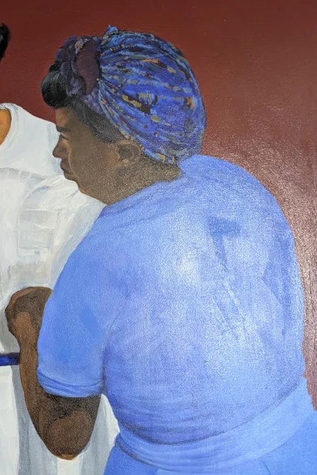 Detail of the woman at right in blue, patterned head wrap.